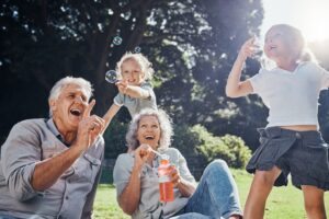 Grandparents laughing with grandchildren blowing bubbles